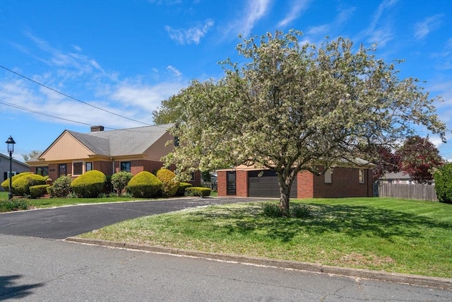 view of front of house with brick siding, asphalt driveway, and an attached garage