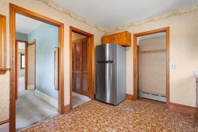 kitchen with freestanding refrigerator, baseboard heating, baseboards, a baseboard heating unit, and light floors