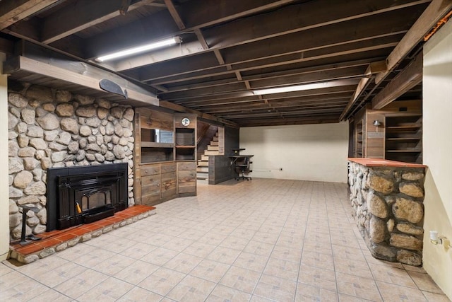 finished basement with stairway and a warm lit fireplace