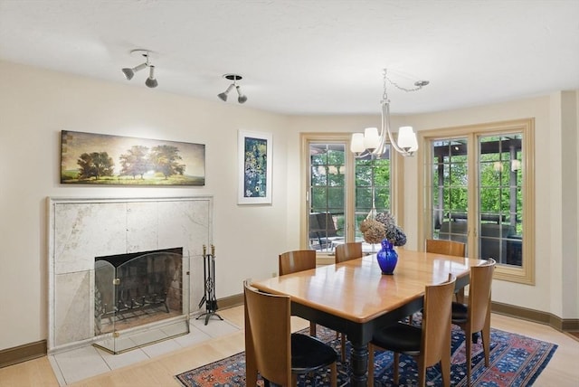 12 Vose Hill Rd, Westford, MA 01886 - dining space with a chandelier, baseboards, a premium fireplace, and light wood-type flooring