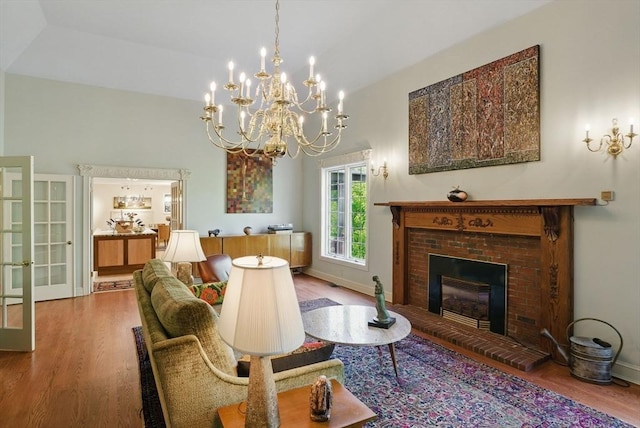 12 Vose Hill Rd, Westford, MA 01886 - living area with wood finished floors, a brick fireplace, a chandelier, and baseboards