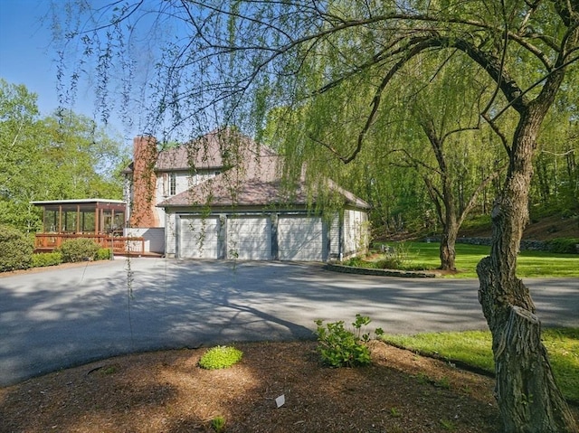 12 Vose Hill Rd, Westford, MA 01886 - exterior space featuring a garage, a sunroom, driveway, and a chimney