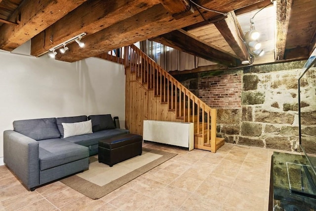 below grade area featuring track lighting and stairs