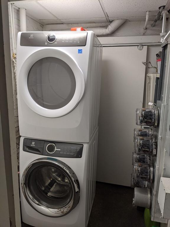 laundry room with stacked washing machine and dryer