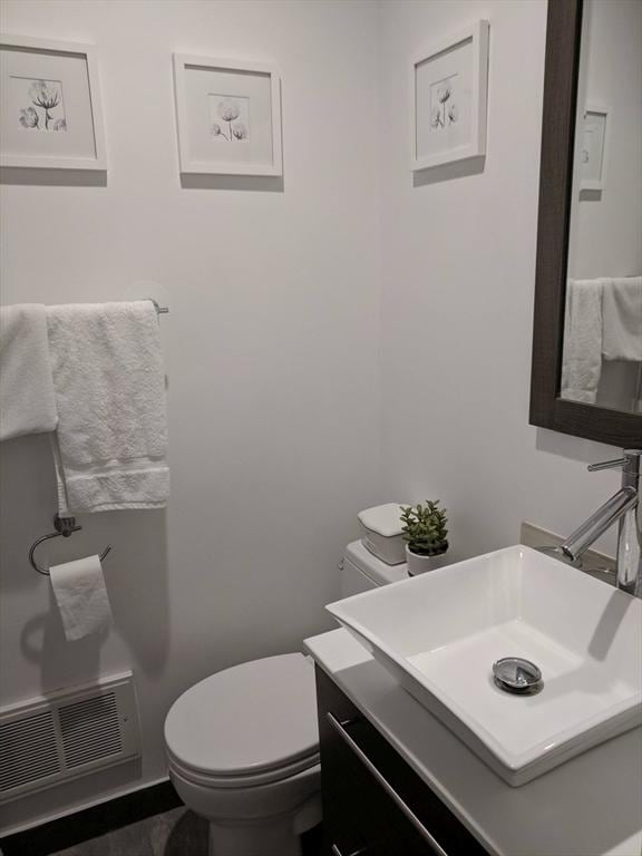 half bathroom featuring vanity and toilet