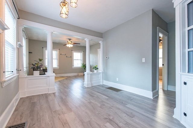 entryway with light wood-style flooring, visible vents, and ornate columns