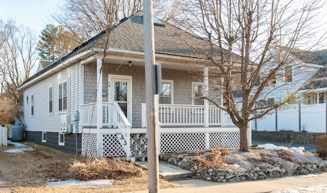 view of side of property featuring a porch and a shingled roof