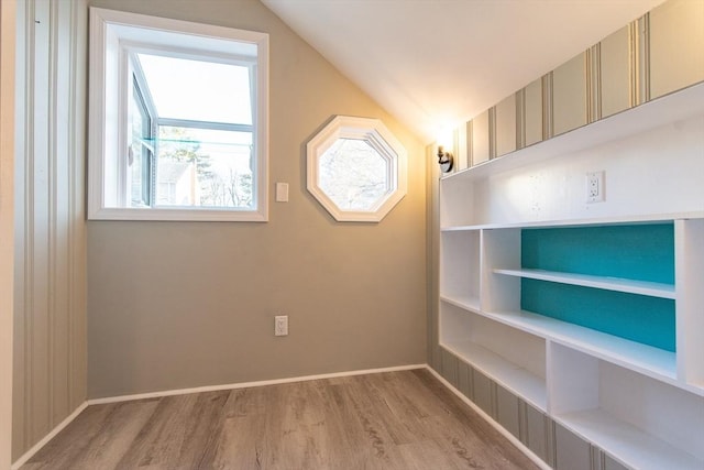 additional living space featuring lofted ceiling, wood finished floors, and baseboards