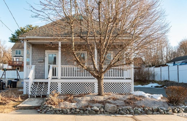 view of front of home featuring fence and a porch