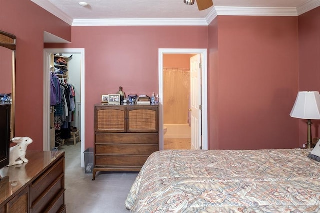bedroom featuring crown molding, ensuite bath, a walk in closet, and a closet