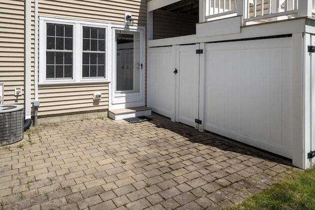 view of patio with an attached garage, entry steps, and cooling unit