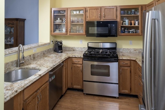 kitchen featuring brown cabinets, stainless steel appliances, and a sink
