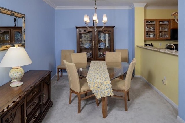 dining area with baseboards, a notable chandelier, light carpet, and ornamental molding
