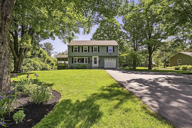1112 Highland St, Holliston, MA 01746 - colonial house featuring asphalt driveway, a garage, and a front yard