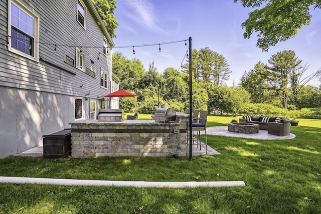 1112 Highland St, Holliston, MA 01746 - view of green lawn with an outdoor fire pit, exterior kitchen, and a patio