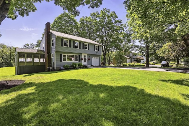 1112 Highland St, Holliston, MA 01746 - colonial-style house featuring a chimney, asphalt driveway, an attached garage, and a front yard