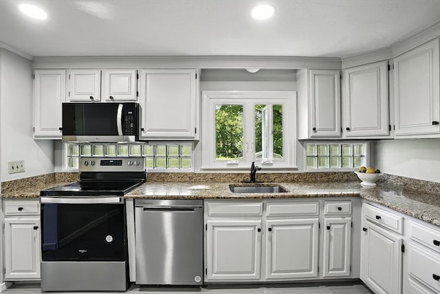 1112 Highland St, Holliston, MA 01746 - kitchen with stainless steel appliances, a sink, white cabinets, and stone counters