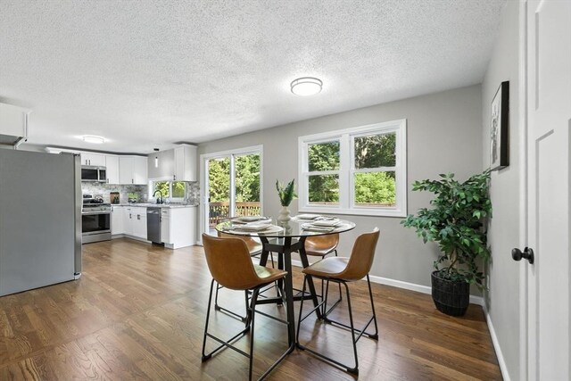 908 Tinkham Rd, Wilbraham, MA 01095 - dining space with a textured ceiling and dark wood-style flooring
