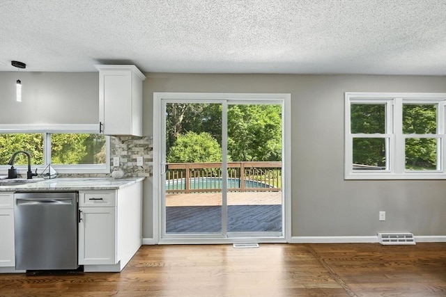 908 Tinkham Rd, Wilbraham, MA 01095 - kitchen with stainless steel dishwasher, white cabinets, wood finished floors, a textured ceiling, and light stone countertops