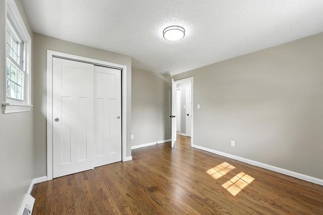 908 Tinkham Rd, Wilbraham, MA 01095 - unfurnished bedroom with a textured ceiling, wood finished floors, and a closet