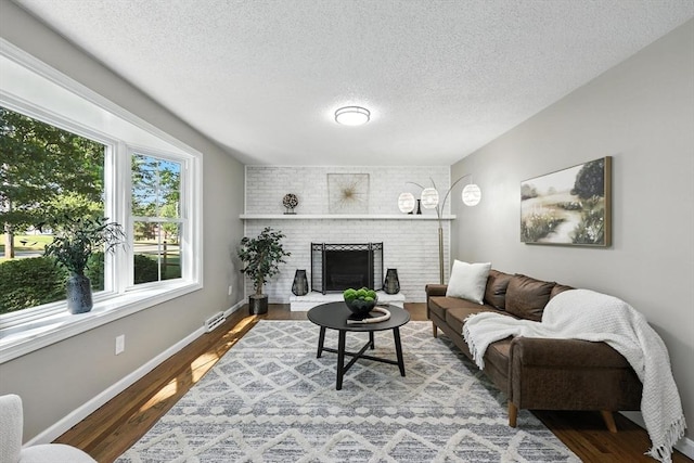 908 Tinkham Rd, Wilbraham, MA 01095 - living room with a textured ceiling, wood finished floors, and a fireplace