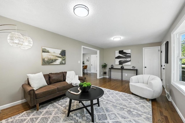 908 Tinkham Rd, Wilbraham, MA 01095 - living room featuring wood finished floors, a chandelier, and a textured ceiling