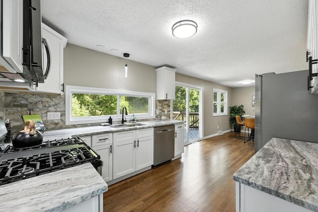 908 Tinkham Rd, Wilbraham, MA 01095 - kitchen featuring appliances with stainless steel finishes, a textured ceiling, decorative backsplash, white cabinetry, and dark wood-style flooring