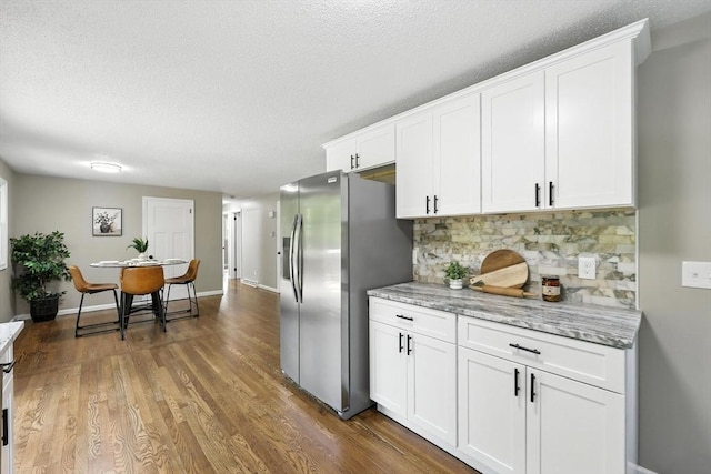 908 Tinkham Rd, Wilbraham, MA 01095 - kitchen with stainless steel fridge with ice dispenser, backsplash, white cabinetry, wood finished floors, and a textured ceiling