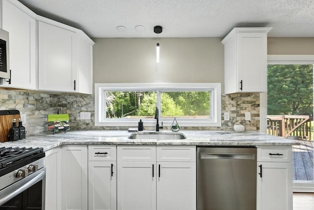 908 Tinkham Rd, Wilbraham, MA 01095 - kitchen with stainless steel appliances, plenty of natural light, white cabinets, and a textured ceiling