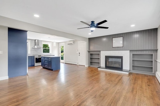 93 Pittroff Ave, South Hadley, MA 01075 - unfurnished living room featuring an AC wall unit, a baseboard radiator, ceiling fan, a glass covered fireplace, and built in features