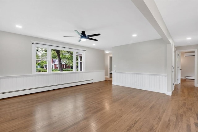 93 Pittroff Ave, South Hadley, MA 01075 - spare room with a baseboard radiator, a wall unit AC, a wainscoted wall, ceiling fan, and wood finished floors