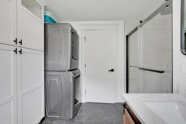 93 Pittroff Ave, South Hadley, MA 01075 - laundry room featuring stacked washer and clothes dryer, cabinet space, and dark tile patterned floors
