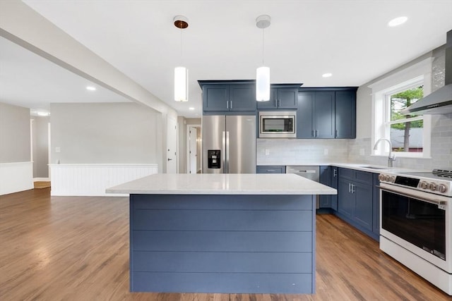 93 Pittroff Ave, South Hadley, MA 01075 - kitchen featuring appliances with stainless steel finishes, light countertops, tasteful backsplash, wall chimney range hood, and wood finished floors