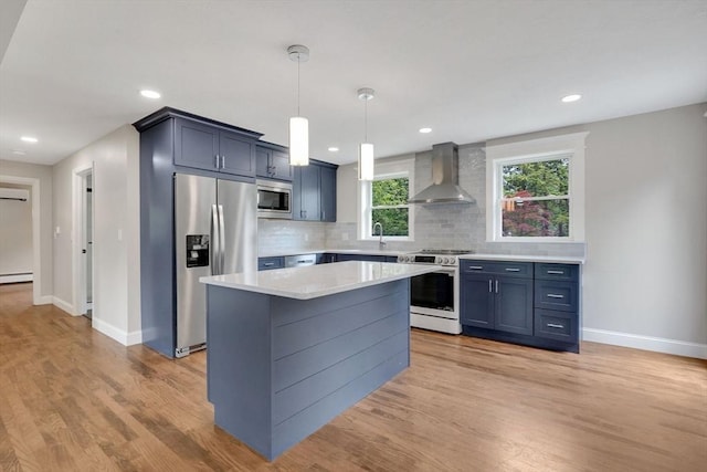93 Pittroff Ave, South Hadley, MA 01075 - kitchen with appliances with stainless steel finishes, wall chimney range hood, light countertops, tasteful backsplash, and light wood-style flooring