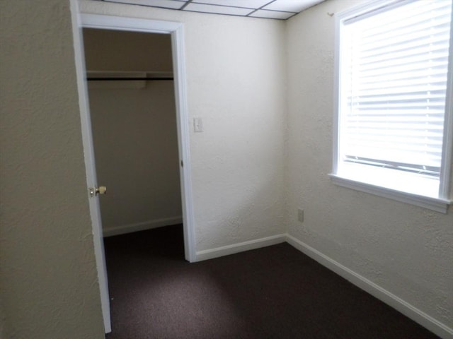 57 Bloomingdale St, Chelsea, MA 02150 - unfurnished bedroom featuring a closet, dark colored carpet, baseboards, and a textured wall