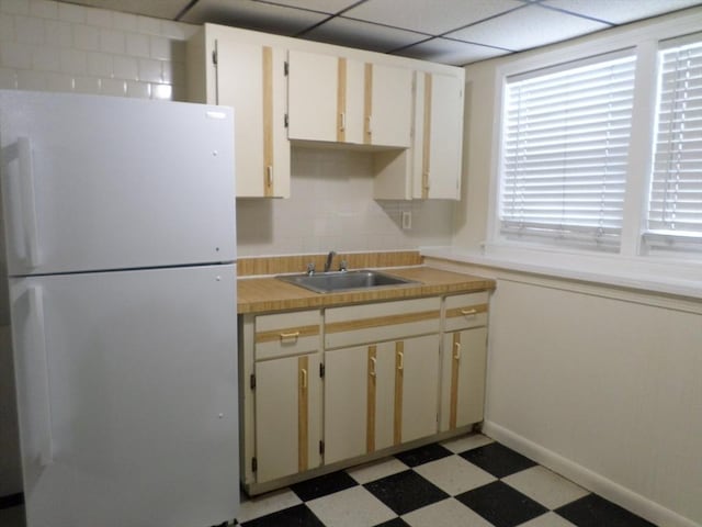 57 Bloomingdale St, Chelsea, MA 02150 - kitchen with light floors, baseboards, freestanding refrigerator, a sink, and light countertops