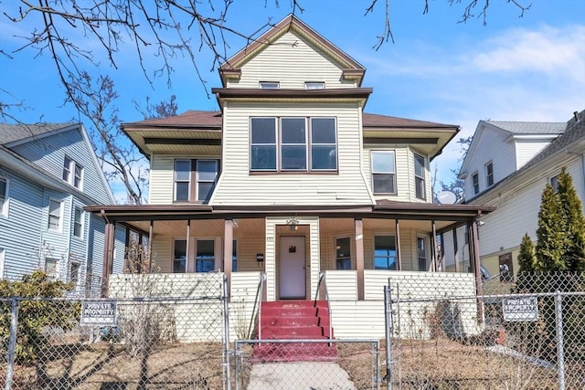 view of front of property with covered porch, a fenced front yard, and a gate