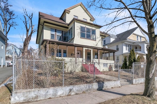 view of front of house featuring a porch, a gate, and a fenced front yard