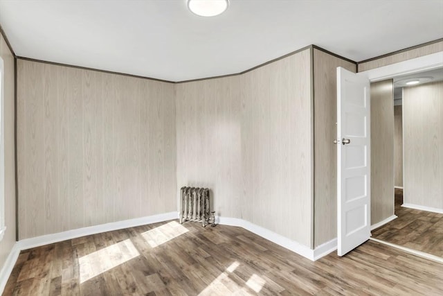 spare room featuring wood finished floors and baseboards