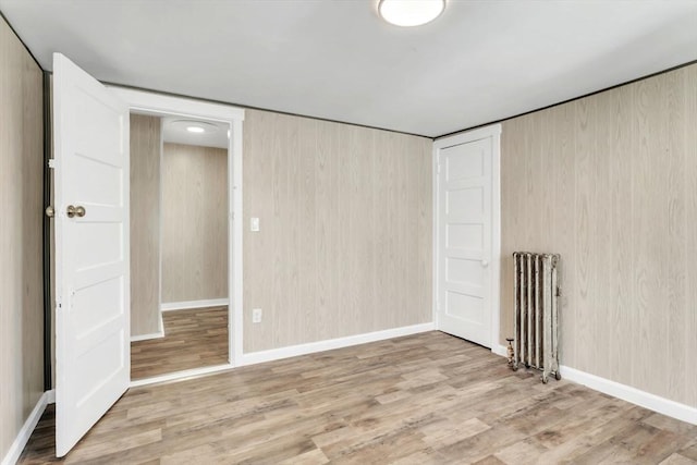 interior space with baseboards, radiator heating unit, and wood finished floors