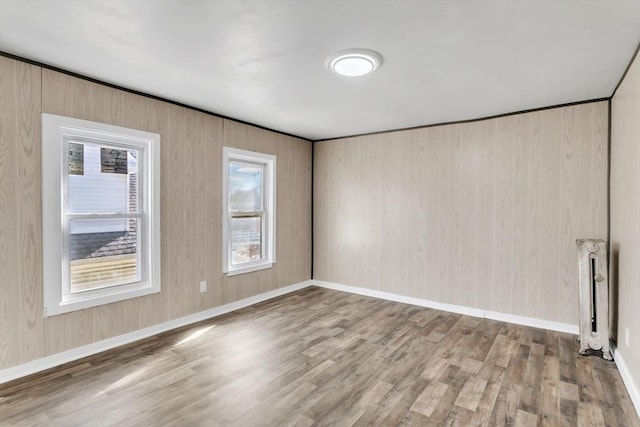 empty room featuring wood finished floors and baseboards