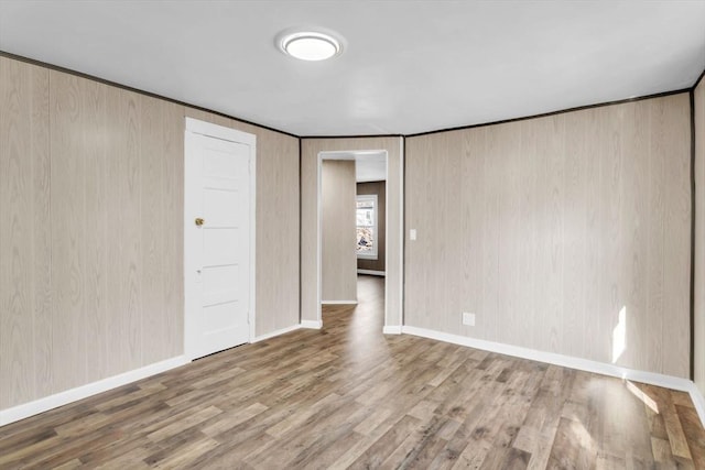 spare room featuring baseboards and wood finished floors