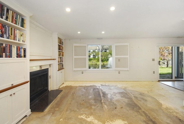 unfurnished living room with recessed lighting, plenty of natural light, built in features, and a fireplace