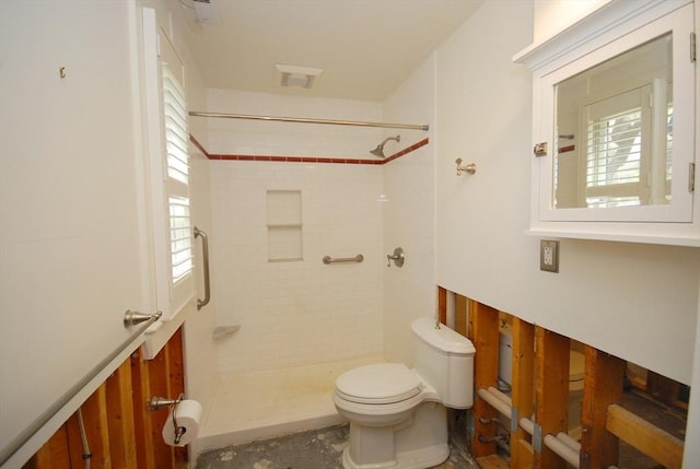 full bath with toilet and tiled shower