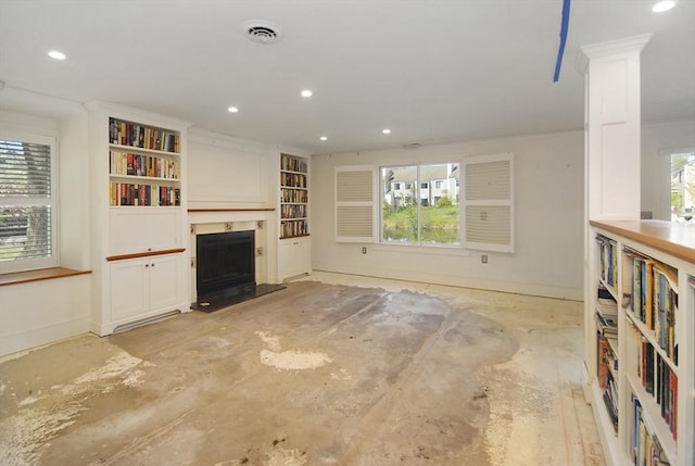 unfurnished living room featuring baseboards, a fireplace with raised hearth, recessed lighting, and visible vents