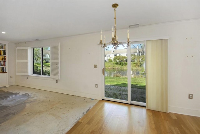 unfurnished dining area with an inviting chandelier, baseboards, wood finished floors, and visible vents
