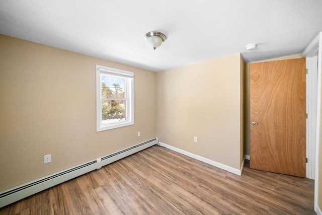 empty room featuring a baseboard radiator, light wood-style flooring, and baseboards