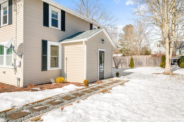 view of snow covered exterior with fence