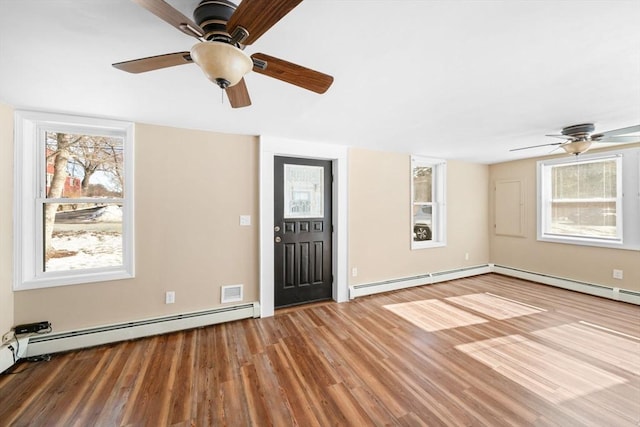 foyer entrance with baseboard heating and wood finished floors