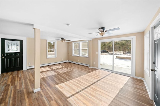 interior space with a ceiling fan, baseboards, and wood finished floors